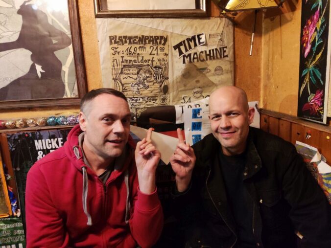 Uli und Steffen, DJs von 1994 vor selbst gemaltem Plakat
